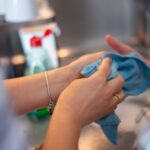 Detailed image of two people cleaning using a blue cloth indoors. Perfect for hygiene concepts.